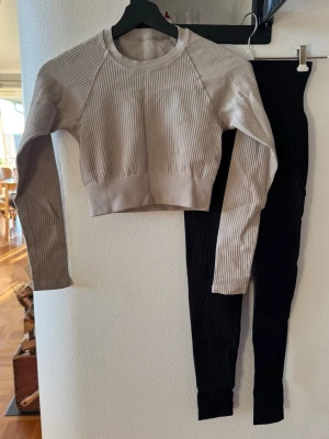 Träningsset från Soc - Jättesköna svarta träningstights i XXS, men otroligt stretchiga, passar XXS-S.  Beige långärmad och croppad träningstopp i XS/S. 🧘🏻‍♀️🌸 Båda använda fåtal gånger, men fint skick.  Säljs separat eller båda.  Tightsen separat: 250 kr (Nypris 500 kr) Toppen separat: 200 kr (Nypris 400 kr)