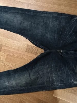 Mörkblå baggy jeans - Säljer ett par mörkblå jeans med bra passform. Jeansen har klassiska bakfickor och är tillverkade i robust denim. Perfekta för dig som gillar en avslappnad och trendig stil.