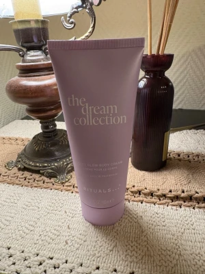 Rituals The Dream Collection Body Cream - Använd fåtal gånger. Ljuslila tub med body cream från Rituals The Dream Collection. Doft av pure daisy och moonstone. Tuben rymmer 100 ml och har en stilren, modern design med mjuk finish. Perfekt för dig som vill ha en återfuktande och lyxig kroppskräm.