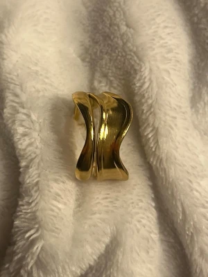 ✨Guldig vågig statementring✨ - Superfin guldring med vågig design som ger ett modernt uttryck ✨ Den öppna formen gör ringen bekväm att bära och enkel att matcha med andra smycken.  ✨ Trendig chuncky & vågig form ✨ Öppen/justerbar modell ✨ Perfekt som statement eller till vardags ✨ Passar både vardag och fest  I fint skick 🤍 Skickas snabbt 📦 Skriv om du vill ha fler bilder!