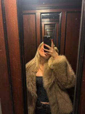 Brun pälsjacka med bred krage - Säljer en snygg brun pälsjacka med bred krage och lång ärm. Jackan har en oversized och fluffig look som ger en elegant look. Perfekt till vardags som fest!