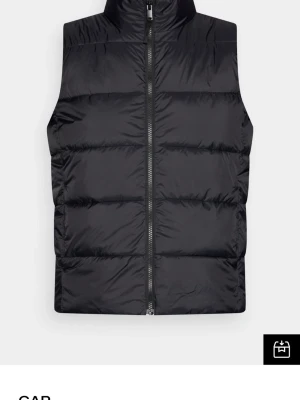 Väst - Stilren svart dunväst från GAP med hög krage och dragkedja framtill. Perfekt för lager-på-lager och ger en clean look till din outfit.