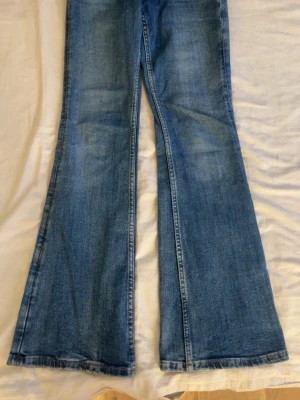 Blå bootcut jeans med utsvängda ben - Säljer ett par klassiska blå jeans med riktigt utsvängda ben i bootcut-modell. Jeansen har en snygg tvätt och normal passform upptill. Perfekta för dig som vill ha en retro och trendig look. Materialet är jeans i bomull. aldrig använda, köpt för 400kr