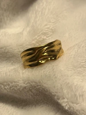 ✨ Guldring – vågig & trendig ✨ - Superfin guldring med mjuk, vågig design som ger ett modernt och stilrent uttryck ✨ Den öppna formen gör ringen bekväm att bära och enkel att matcha med andra smycken.  ✨ Trendig vågig form ✨ Öppen/justerbar modell ✨ Perfekt som statement eller till vardags ✨ Passar både vardag och fest  I fint skick 🤍 Skickas snabbt 📦 Skriv om du vill ha fler bilder!