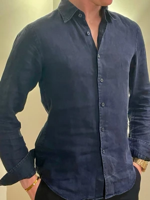 Mörkblå linneskjorta - Klassisk mörkblå linne skjorta från Uniqlo. Skjortan har en avslappnad passform, perfekt för en trendig och bekväm look. Storlek XXS men passar XS