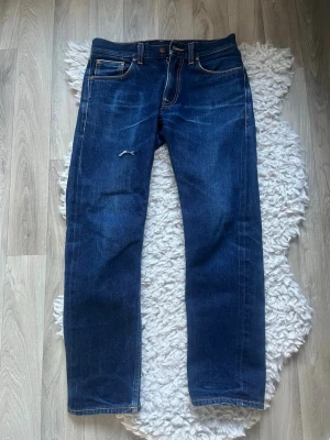 Nudie Jeans ”Gritty Jackson” Selvadge - Ett par riktigt feta Nudie gritty jackson selvedge jeans i storlek 29x30, nypris ca. 1700kr. De är i perfekt skick förutom ett litet hål på framsida lår vilket man ser på den första bilden. Hålet går däremot att laga helt gratis på närmsta Nudie butik. Tveka inte på att höra av er vid frågor🤠
