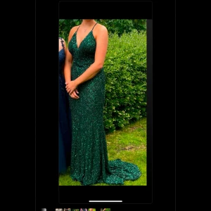 Grön glittrig långklänning - Kollar nu intresset för min fantastiska balklänning!🥰Super snygg grön långklänning med glittrigt mönster och djup v-ringning. Klänningen har smala axelband och en öppen rygg. Endast använd en kväll, funderar på att sälja då jag inte ser någon användning för den och hoppas att någon annan ska få en fantastisk kväll i samma klänning🫶 Från dressroom Linné, Nypris: 4999! Skickas i tillhörande klänningfodral. Finns i Halmstad