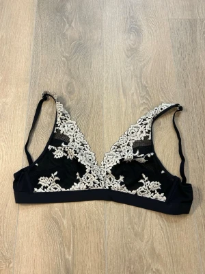 Intimissimi spets-bh  - Intimissimi bygel med vit blommig spetsbrodyr över hela kuporna. 