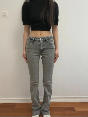 Grå jeansbyxor från Vailent - Säljer ett par grå jeansbyxor från Vailent med raka ben och snygga fickor bak med lock och knapp. Byxorna har låg midja och klassisk femficksdesign. Perfekta till en avslappnad look och passar till det mesta.