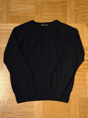 Mörkblå kashmirtröja Oscar Jacobson - Mörkblå Ulltröja från Oscar Jacobson i mycket bra skick. Storlek S, har ej krympt. Är 180cm och väger 68kg. Skriv för fler bilder/frågor.