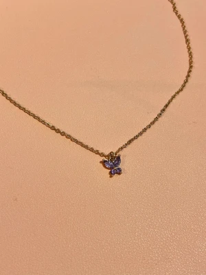 Guldigt fjärilshalsband - Ett guldigt fjärilshalsband som har använts några gånger💜