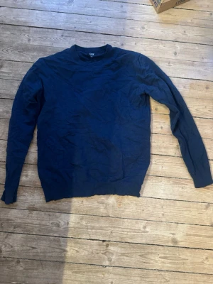 Mörkblå tröja från Cutter & Buck XL - En enkel och stilren mörkblå tröja från Cutter & Buck i storlek XL. Tröjan har rund halsringning och långa ärmar, perfekt för lager på lager under kyligare dagar. Tillverkad i mjukt material som känns skönt mot huden.