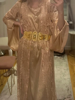 Kurdiska klänning med guldbälte  - Säljer min kurdiska klänning med guldbälte. Tvådelad Kawa i satin/kras. Endast använd en gång. Passar storlek XS/S. Helt ny! Endast testad