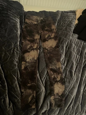 SOC camo träningsbyxor i brun/grå - Säljer ett par träningsbyxor från SOC i brun och grå camouflage i storlek 146-152. Byxorna har rak passform och har en elastisk midja. Funderingar? Skriv till mig💕