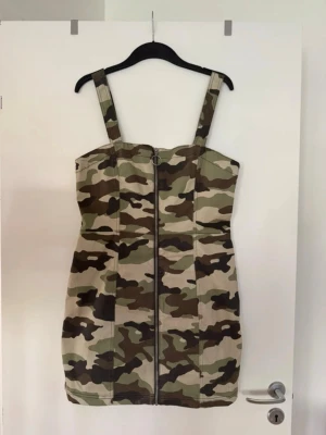 Hängselklänning militär  - Storlek 44, liten i storlek. Aldrig använd. 