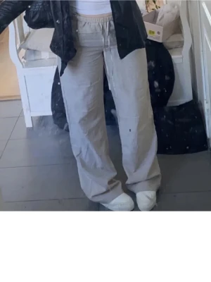 Beiga linnebyxor  - Säljer ett par beiga linnebyxor med bred passform och resår i midjan samt snörning. Byxorna är raka och har en avslappnad, loose fit. Perfekta för varmare dagar och riktigt sköna att bära. Materialet är tunt och luftigt linne. Uppspättade längst ned (se bild) men inget som man märker. Tveka inte att höra av dig vid frågor!