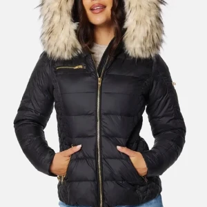 Svart jacka med ”fusk”päls - Säljer en svart pufferjacka från Rockandblue med stor luva kantad av beige fuskpäls. Jackan har guldfärgade dragkedjor, tre fickor fram och quiltad design. Perfekt för kalla dagar och riktigt snygg till jeans eller tights.