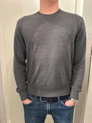 Sandö Merinoull  - En riktigt snygg tröja från Sandö i 100% merinoull. Tröjan är ganska slim fit och följer kroppen riktigt snyggt. Storleken är S och modellen är 176cm. Färgen är mörkgrå. Tveka inte med att ställa frågor! 