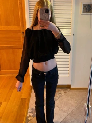 Svart blus - En fin svart blus som man ser lite igenom längs armarna. Storlek 134/140💘