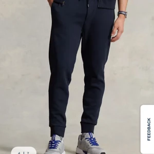 Mörkblå mjukisbyxor Polo Ralph Lauren - Double-knit jogging-bottom. Använda 1 gång. Absolut nyskick. Storlek S/170. Mörkblå mjukisbyxor från Polo Ralph Lauren med dragsko i midjan och klassisk logga broderad på ena benet.  Byxorna har ribbade muddar vid bensluten och en bakficka. Första bilden är lånad.