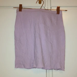 Ljuslila ribbad kjol från Shein - Säljer en ljuslila ribbad kortkjol från Shein i storlek XS. Kjolen har en rak passform och är tillverkad i ett mjukt, stretchigt material. Perfekt att styla med en oversized hoodie eller crop top. Använd ett fåtal gånger men väldigt bra skick!!