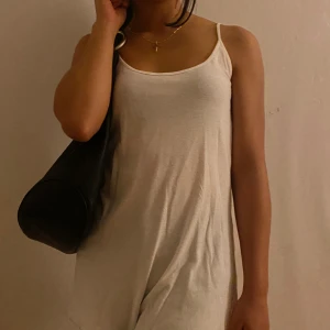 Vit ärmlös kortklänning med smala axelband - Enkel och stilren vit kortklänning med smala axelband och rak passform. Klänningen är ärmlös och har en lätt, flowy känsla som passar perfekt till varma dagar. Kan stylas bara som en klänning eller med byxor 💗