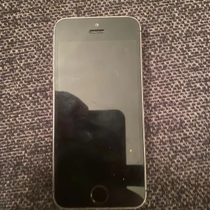 iPhone SE - Säljer en Apple iPhone SE i klassisk Space Gray. Telefonen har mindre spår av användning men ser överlag fin ut. Skärmen och baksidan är hela utan synliga sprickor. Perfekt som reservtelefon eller för dig som vill ha en kompakt smartphone.