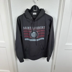 Saint Laurent hoodie - Säljer nu denna sjukt feta Saint Laurent hoodie i den mest eftertraktade designen | Storleken är M men sitter som en S | modellen på bilden är runt 180 | tröjan har inga defekter eller skador och är i fint skick 