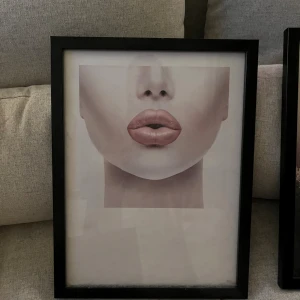 Svart fotoram med glas, 2-pack - Snygga svarta fotoramar med glasfront, passar till A4-format. Båda ramarna har metallfästen för enkel upphängning. Skicket är gott, med mindre tecken på användning. Perfekt för foton eller konstverk i hemmet eller kontoret. Följer med två posters från Desenio 