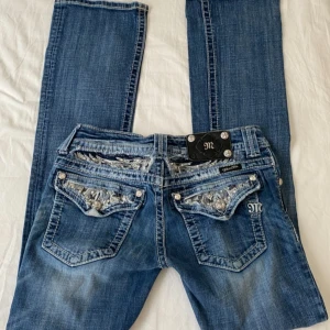 Miss Me blå bootcut jeans med broderi - Snygga lågmidjade jeans från Miss Me med bootcut passform. Jeansen har detaljerade bakfickor med broderier, nitar och dekorativa sömmar.  Midjemått 35-36 cm, innerben 84 cm💓