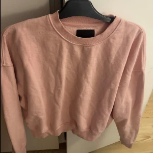 Rosa sweatshirt med rund hals - En enkel och snygg ljusrosa sweatshirt med rund hals och långa ärmar. 