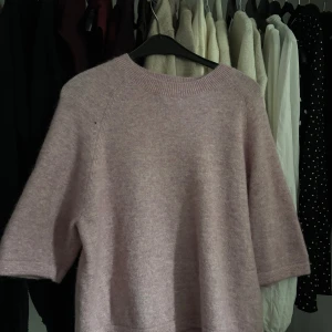 Trekvarts tröja - Supermysig ljuslila trekvarts tröja med korta ärmar och rund hals. Perfekt för lager-på-lager under höst och vinter. Mjuk och fluffig känsla, passar dig som gillar chill och enkel stil. Den är ljusrosa, och skön. Den har litet hål vid axel men inget som syns jätte mycket 