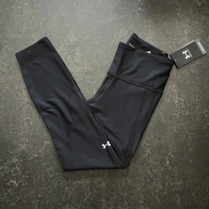 Svarta ankle leggings från Under Armour - Svarta ankle leggings från Under Armour med hög midja och kompressionseffekt.  Stl M                  Helt ny