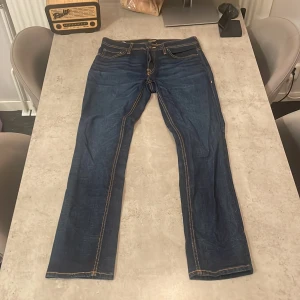Mörkblå jeans från Jack & Jones - Snygga mörkblå jeans från Jack & Jones med klassisk femficksdesign och kontrastsömmar. Jeansen har rak passform och är tillverkade i slitstarkt denimtyg. Perfekta för dig som gillar en tidlös och enkel stil.