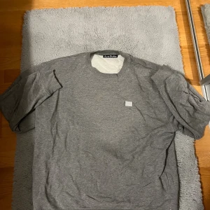 Grå sweatshirt från Acne Studios - Tja! Säljer nu min stilrena Grå sweatshirt från Acne Studios i 100% bomull. Klassisk rund halsringning och diskret Acne Studios-face patch på bröstet. Perfekt basic med relaxed fit och ribbade muddar vid ärmslut och nederkant. Vid frågor så är det bara att ställa!