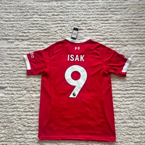 Isak Liverpool home jersey 25/26 - Brand new Isak the Great shirt with premier league patch. Completely unused.🫱🏻🫲🏻  The reason these jerseys cost a bit more than the others is because I paid for FedEx express shipping and customs, and I want to give you the chance to get this jersey before anyone else 🤝🏼