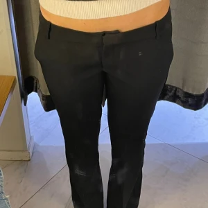Low waist svarta kostymbyxor med bootcut - Svarta lågmidjade kostymbyxor med bootcut. Bra skick!! Jag är 175 cm lång