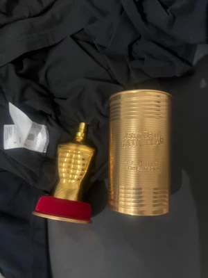 Jean Paul Gaultier elixir absolute  - Limited edition Le Male i guld, med ikonisk burk och flaska. Perfekt för dig som vill sticka ut med en lyxig och unik parfymdesign. Snygg samlarflaska som passar i hyllan.