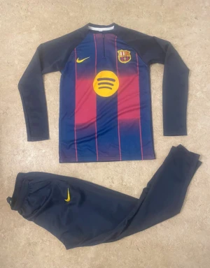 FC Barcelona långärmad Nike fotbollströja - Säljer en långärmad FC Barcelona fotbollströja från Nike med klassiska blå och vinröda ränder, gul Nike-logga och Spotify-sponsor på bröstet. Materialet är lätt och andas, perfekt för träning eller match. Tröjan har halv dragkedja och klubbmärke på bröstet.