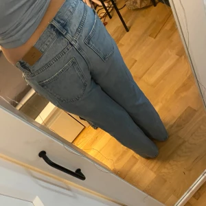 Blå lågmidjade jeans  - Snygga ljusblå jeans en klassisk femficksdesign. De är bootcut lågmidjade och är tillverkade i denim med en knappgylf. 