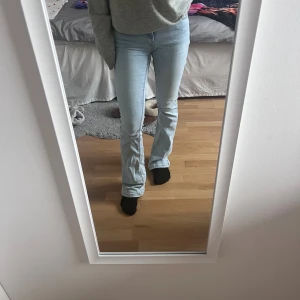 Ljusblå bootcut jeans  - Ljusblå bootcut jeans från Gina Tricot i storlek 32 med medelhög midja. De är slitna i resåren som visas på bilden då de är för långa för mig, samt en liten fläck på högra bakfickan. Annars i gott skick och fin passform. Säljer som sagt för att jag inte längre gillar midjan och på grund av längden. 🤍