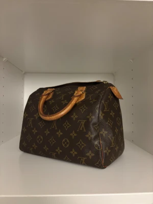 Louis Vuitton speedy 25 - Säljer denna klassiska handväska från Louis Vuitton modell Speedy 25, äkta, köpte secondhand av företaget Sole Plus. Säljer då den inte kommer till användning! Väldigt fint skick endast trasig vid dragkedjan som man ser på bilden! Vid intresse hör av dig 💖💖