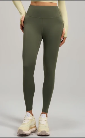 Olivgröna leggings  - Snygga olivgröna leggings i stretchigt syntetmaterial med hög midja och tight passform. Perfekta för träning eller chill, med slät yta och sömmar som ger en clean look. Kommer i originalförpackning.