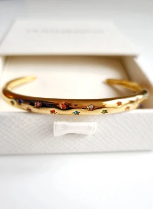 armband 18k guldpläterat  - Snyggt guldpläterat armband med öppet avslut. Armbandet är dekorerat med små stjärnformade infattningar i olika färger som blått, rött, grönt, orange och vitt. Perfekt för dig som gillar färgglada detaljer och stilren design. Lådan ingår ej.