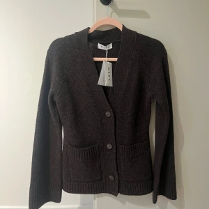 Mörkbrun stickad kofta från Wera - Slöjder denna fina mörkbruna stickade kofta från Wera i storlek XS. Helt oanvänd! Köpt för 899 kr, öppen för budgivning 