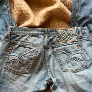 Ljusblå jeans från Pepe Jeans - Säljer ett par ljusblå jeans från Pepe Jeans med snygga detaljer på bakfickorna och ett broderat logomärke på linningen. Klassisk femficksmodell med raka ben och normal passform. Jeansen har slitningar framtill för en cool look. Jag köpte dessa av en tjej på plick❤️||  Mått: Midja:86cm (hela midjemått) Lår: 100cm (hela omkrets) Storlek: 29/38/M ||