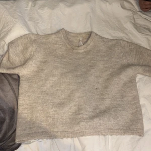 Beige stickad tröja Gina Tricot - Mysig beige stickad tröja från Gina Tricot i storlek 146/152. Tröjan har rund hals och långärmade ärmar, perfekt för att hålla dig varm under kyliga dagar. Enkel och stilren design som är lätt att matcha med dina favoritjeans eller kjol.