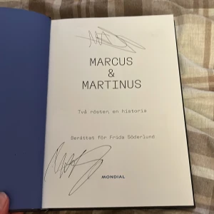 Signerad Marcus & Martinus: Två röster, en historia - Signerad m&m bok! Pris kan absolut diskuteras. Följ med bakom kulisserna på Marcus & Martinus resa från barndomsidoler till vuxna artister. En inspirerande bok om att växa upp i rampljuset, kämpa mot motgångar och hitta sin egen röst. Perfekt för fans och unga som vill veta mer om livet som popstjärna.