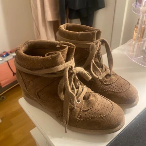 Bruna mockasneakers från Pavement - Snygga bruna sneakers från Pavement i mocka med snörning och perforerade detaljer. Skorna har en dold kilklack och rund tå, har bara använt max 4 gånger 💞 köpta för 1700kr på Nelly