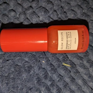 Glow Recipe Strawberry Smooth Serum - Glow Recipe Strawberry Smooth BHA + AHA Salicylic Serum i en snygg röd plastflaska på 10 ml. Perfekt för dig som vill ha en fräsch och glowig hud med hjälp av aktiva ingredienser som BHA och AHA.
